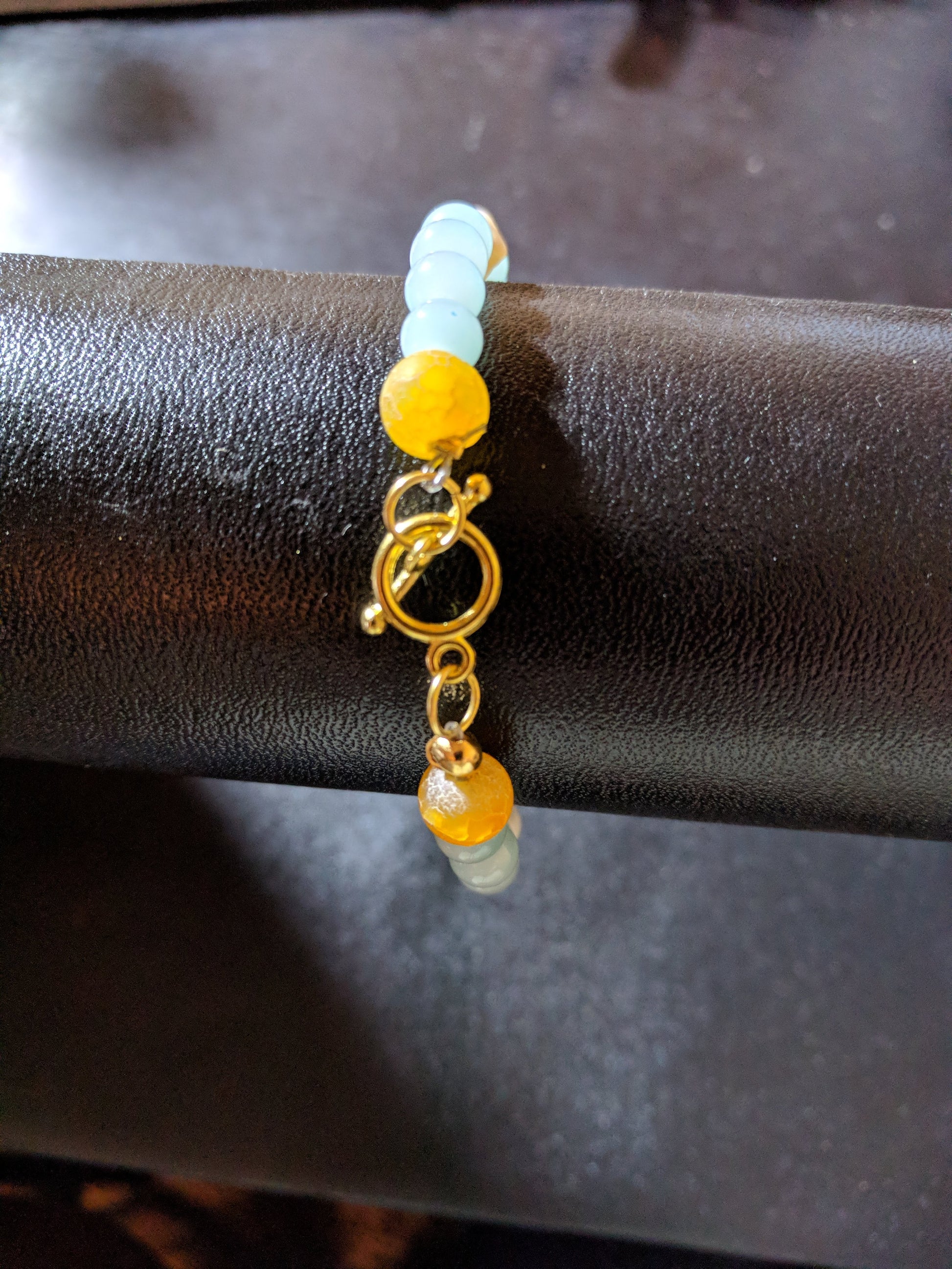 Beaded bracelet showing the gold toned toggle clasp on a black display.