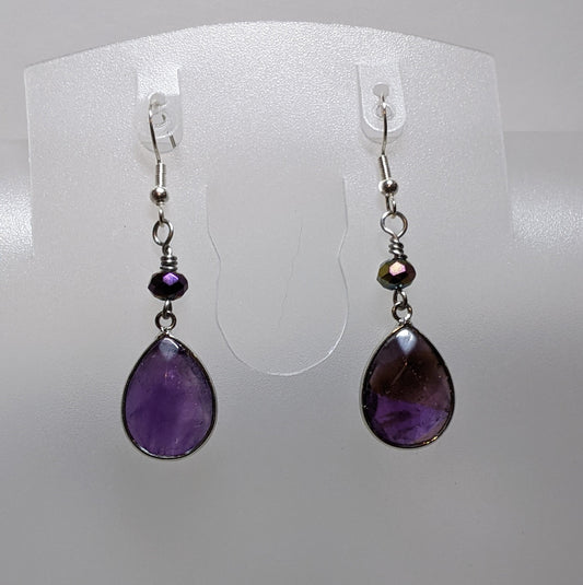 A pair of purple drop earrings with faceted beads, displayed against a white background.