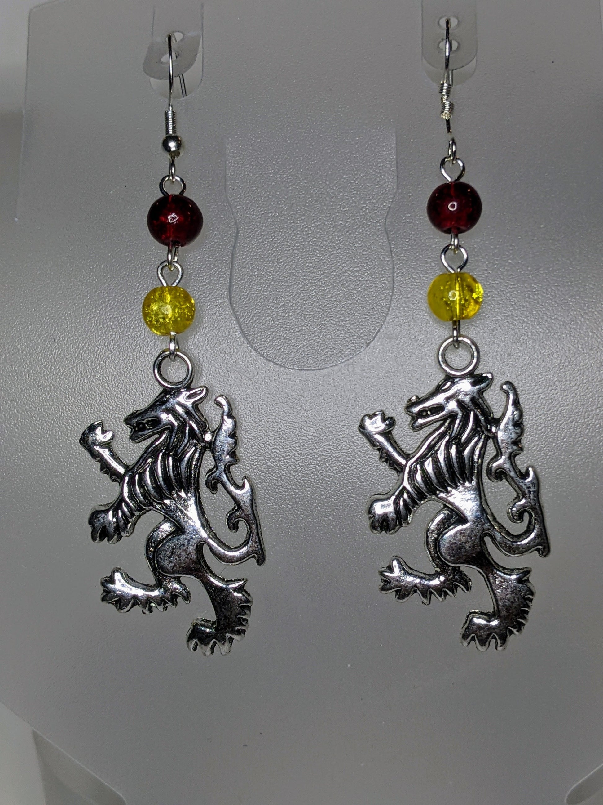 Close up of silver lions rampant facing left wirh red & yellow crackle glass bead accents