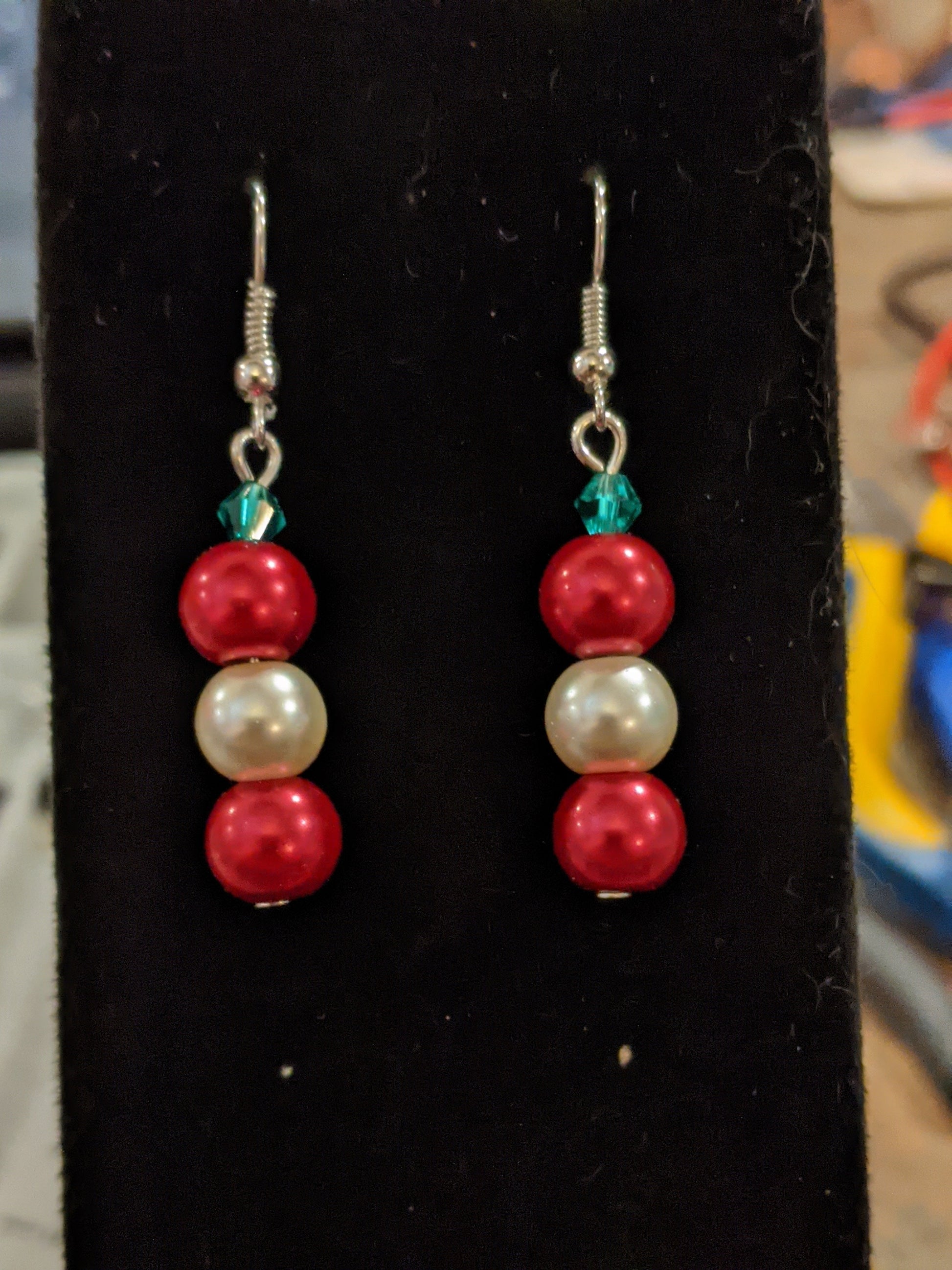 A pair of pearl bead dangle earrings with red and white glass pearls and green faceted bicone, on silver French hook ear wires