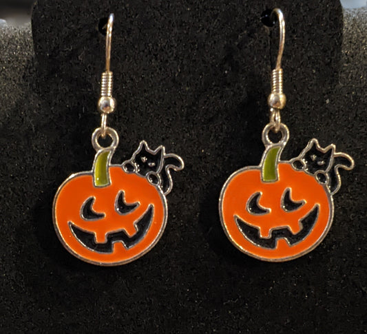 A pair of Halloween-themed earrings featuring jack-o'-lantern designs with black cats.