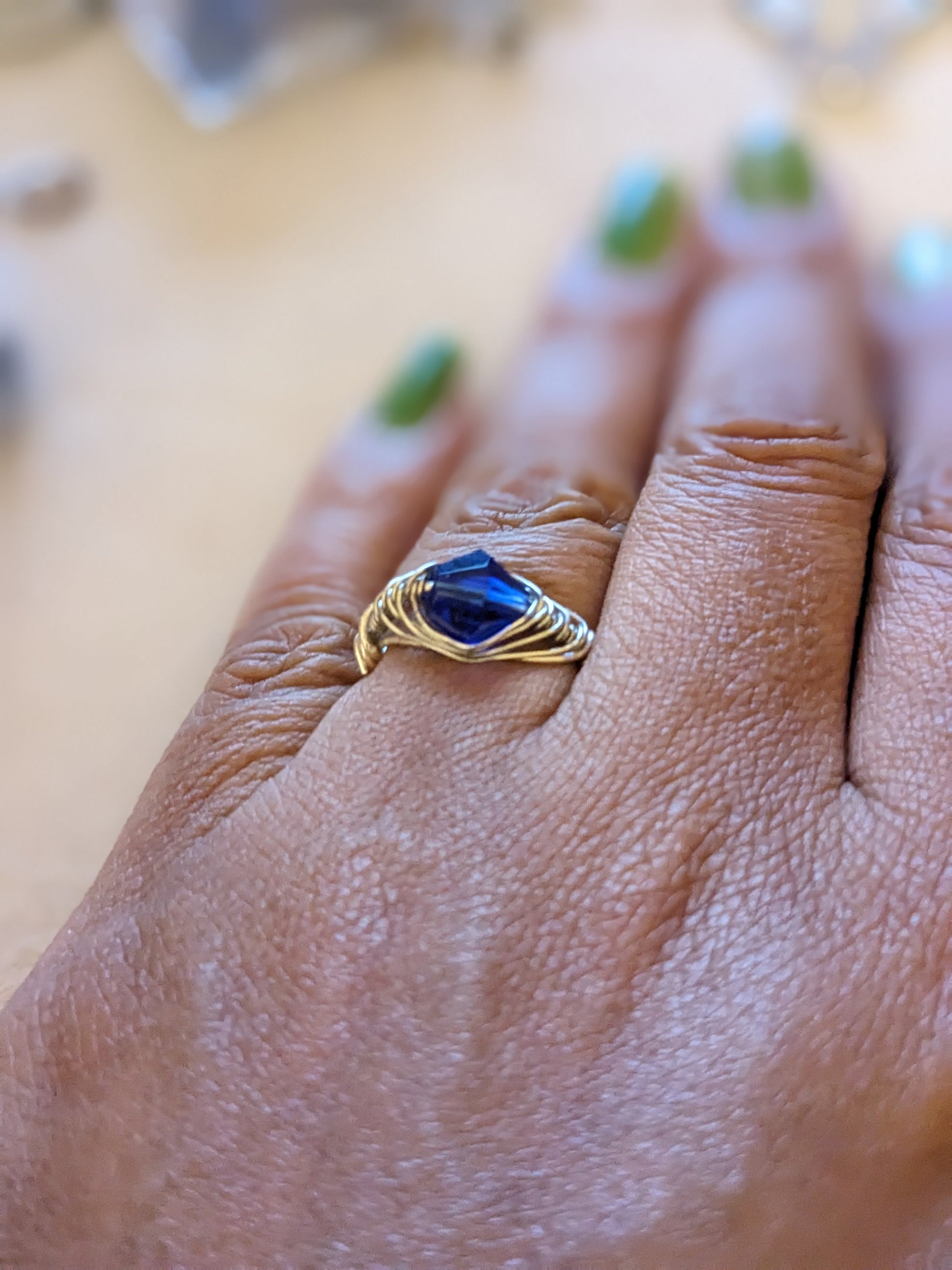 Silver wire wrapped ring with a blue stone on a person's hand