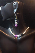 A beaded jewelry set displayed on a mannequin, consisting of a necklace and earrings with asexual pride color accent beads.