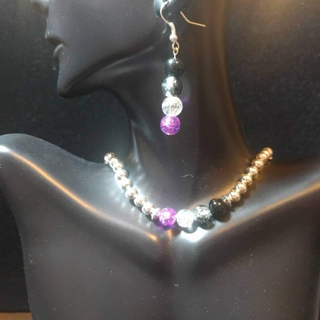 A beaded jewelry set displayed on a mannequin, consisting of a necklace and earrings with asexual pride color accent beads.