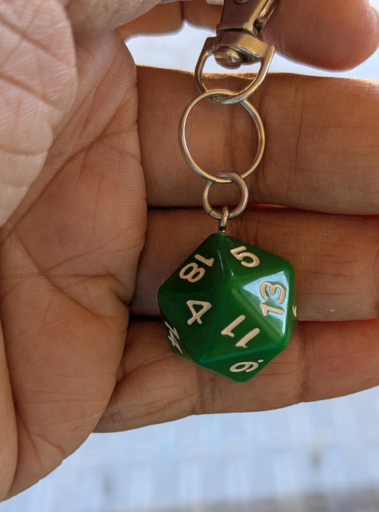 Green D20 keychain held in a person's fingers